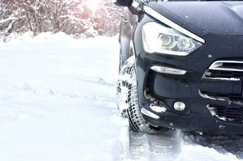 closeup of car and winter tires in snow