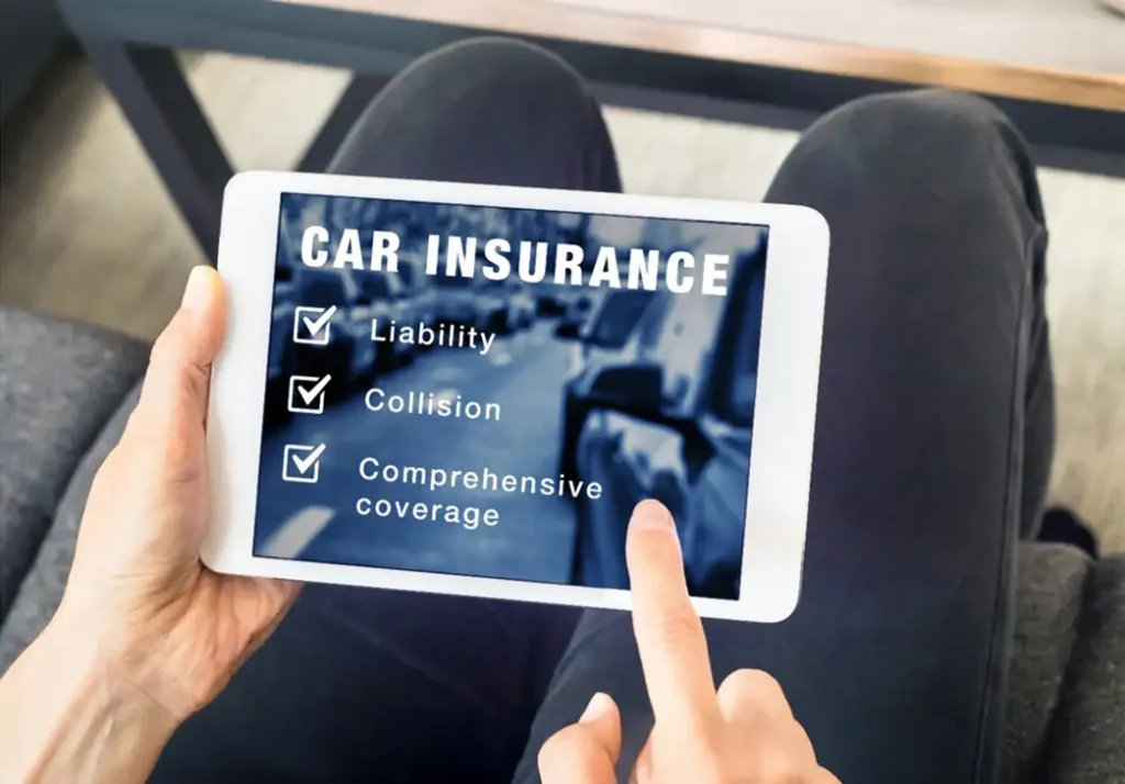 Closeup of a person holding a tablet with car insurance information displayed on it.